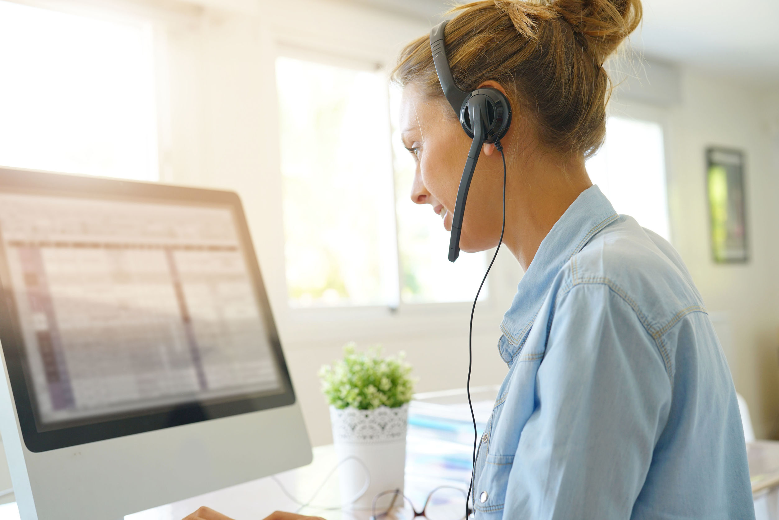 Customer service operator talking on phone in office